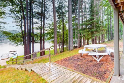 a picnic table and bench next to a lake at Hillis House in Arbor Vitae