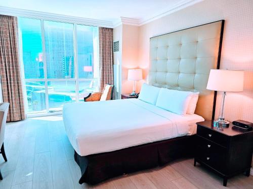 1 dormitorio con cama grande y ventana grande en Strip view 1 BR suite 2 Full Bath Full Kitchen with Balcony - 900 sqft - MGM Signature, en Las Vegas