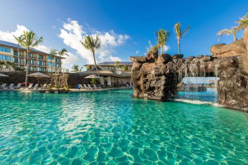 a swimming pool at a resort with palm trees at Koloa Landing Resort at Po'ipu, Autograph Collection in Koloa