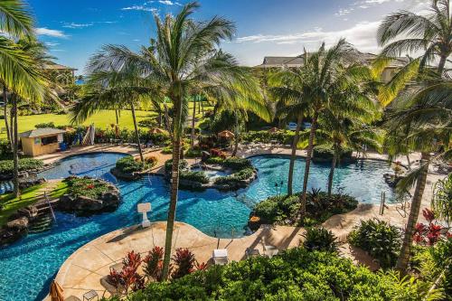 an aerial view of a resort pool with palm trees at Koloa Landing Resort at Po'ipu, Autograph Collection in Koloa