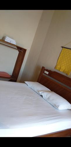 a bedroom with a white bed with a wooden headboard at Village Lagoinha Ceará in Tigre