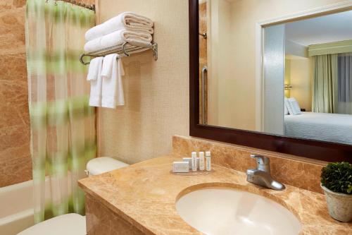 a bathroom with a sink and a mirror at SpringHill Suites Victorville Hesperia in Hesperia