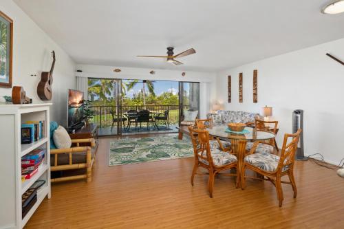 a dining room and living room with a table and chairs at Big Island Keauhou Punahele E202 condo in Kailua-Kona