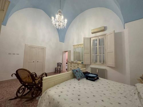 ガリポリにあるCasa Vacanze Gallipoliのベッドルーム1室(ベッド1台、椅子、シャンデリア付)
