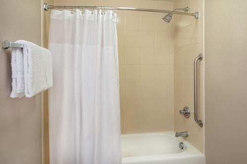 a bathroom with a shower with a white shower curtain at SpringHill Suites by Marriott Norfolk Virginia Beach in Virginia Beach