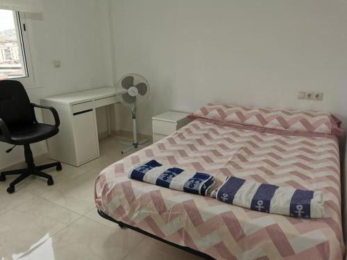 a bedroom with a bed and a desk and a chair at Preciosoy gran apartamento terraza con vistas wifi y climatización in Málaga