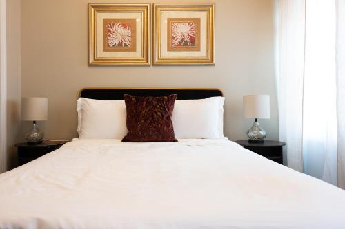 a bedroom with a white bed with two lamps at Luxury Federal Hill Home with Rooftop & 4 Parking Spots in Baltimore