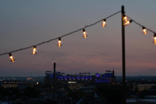 a group of lights hanging over a city at night at Luxury Federal Hill Home with Rooftop & 4 Parking Spots in Baltimore