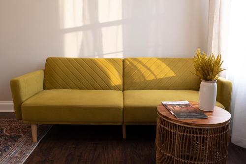 a yellow couch in a living room with a table at Luxury Federal Hill Home with Rooftop & 4 Parking Spots in Baltimore
