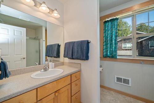 a bathroom with a sink and a mirror and a window at Classic Cottage-MCA #1548 in Manzanita