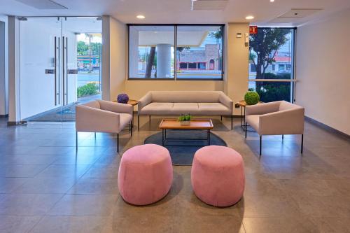 a lobby with couches and a table and chairs at City Express by Marriott Saltillo Norte in Saltillo