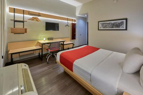 a hotel room with a bed and a desk and a table at City Express by Marriott Saltillo Norte in Saltillo