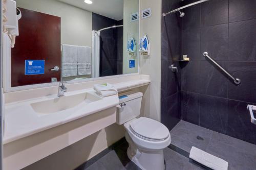 y baño con aseo, lavabo y ducha. en City Express by Marriott Saltillo Norte, en Saltillo