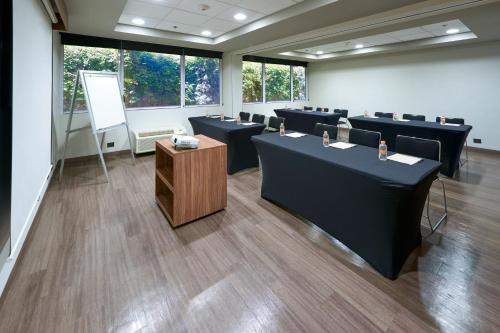 a conference room with black tables and a podium at City Express by Marriott Saltillo Norte in Saltillo