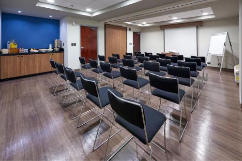 a conference room with chairs and a podium and a screen at City Express by Marriott Saltillo Norte in Saltillo