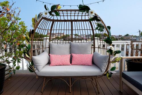 a swing chair with pillows on a balcony at Luxury Federal Hill Home with Rooftop & 4 Parking Spots in Baltimore