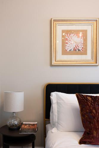 a bedroom with a bed and a table with a lamp at Luxury Federal Hill Home with Rooftop & 4 Parking Spots in Baltimore