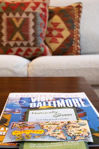 a stack of books sitting on a coffee table at Luxury Federal Hill Home with Rooftop & 4 Parking Spots in Baltimore