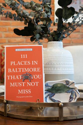 a book sitting on a table next to a vase at Luxury Federal Hill Home with Rooftop & 4 Parking Spots in Baltimore