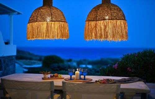 a table with two glasses and two lights at VLIA MAR Myconian Residences in Kalafatis