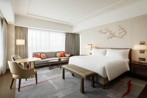 JW Marriott Hotel Nara في نارا: غرفة فندقية بسرير كبير واريكة