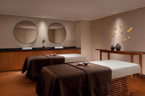 a spa room with two beds and two mirrors at JW Marriott Hotel Nara in Nara