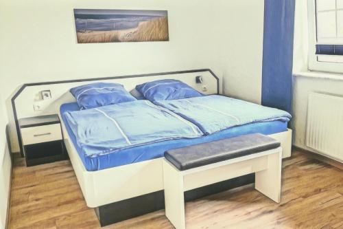 1 dormitorio con 1 cama con sábanas azules en Fregatte Wintergarten, en Wangerooge