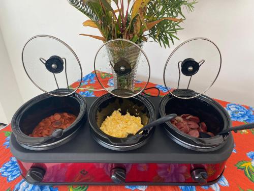 três tigelas de comida num tabuleiro numa mesa em Por do Sol Pousada Praia em São Luís