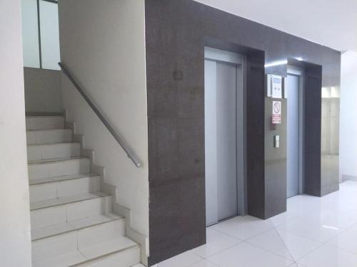 um corredor com escadas e elevadores num edifício em Heart of Lima, Miniapartment Groups, Family, Couples em Lima