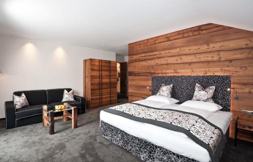 a bedroom with a large bed and a couch at Hotel Restaurant Kirchsteiger in Vollan