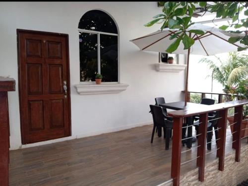 a dining room with a table and chairs and a door at Konchamar in La Libertad