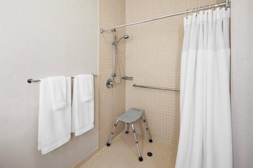 a shower with a shower curtain and a stool in a bathroom at SpringHill Suites Tempe at Arizona Mills Mall in Tempe