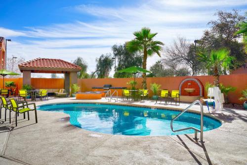 a swimming pool with chairs and tables and a patio at SpringHill Suites Tempe at Arizona Mills Mall in Tempe