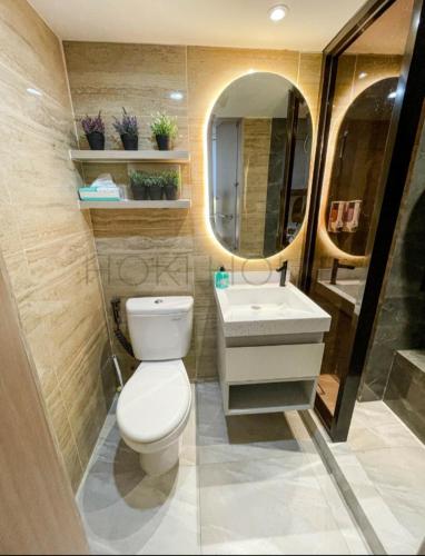 ein Badezimmer mit einem WC, einem Waschbecken und einem Spiegel in der Unterkunft Apartement M-Town Avery Type Studio Gading Serpong Tangerang by HokiHome in Tangerang