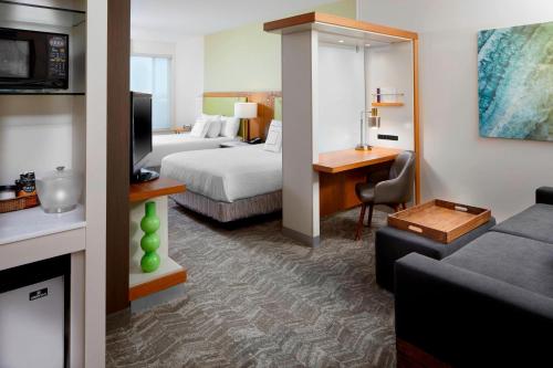 a hotel room with a bed and a living room at SpringHill Suites by Marriott Pittsburgh Bakery Square in Pittsburgh