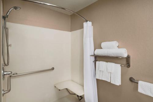 La salle de bains est pourvue d'une douche et de serviettes blanches. dans l'établissement SpringHill Suites Phoenix North, à Phoenix