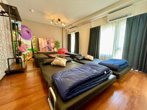 uma sala de estar com duas camas e um sofá em Linkit Stay 東新宿 em Tóquio