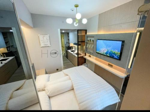 ein Wohnzimmer mit einem Sofa und einem Flachbild-TV in der Unterkunft Apartement M-Town Avery Type Studio Gading Serpong Tangerang by HokiHome in Tangerang