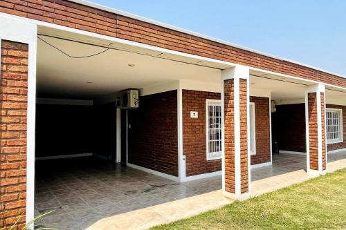 a brick building with an open garage with a brick wall at G6 Monoambiente King con Cochera en Villa Ángela in Villa Ángela