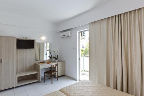 Dormitorio con cama, escritorio y TV en Hotel Africa, en Rodas