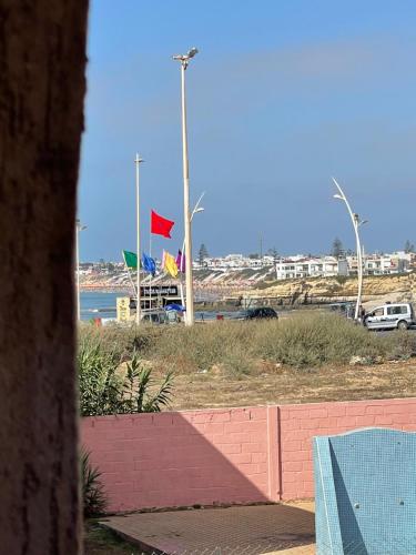 a view of a beach with a red flag at Apparemment élégante a sidi bouzid face a la mere in El Jadida