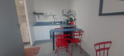a kitchen with red chairs and a blue counter top at Chasqui Jr. in Hacienda San Luis