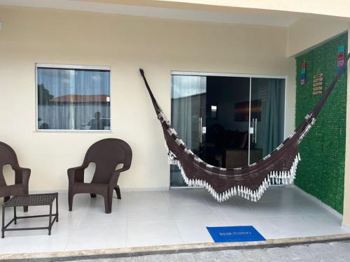 a hammock in a living room with two chairs at Dunas Residence Casa n16 in Santo Amaro