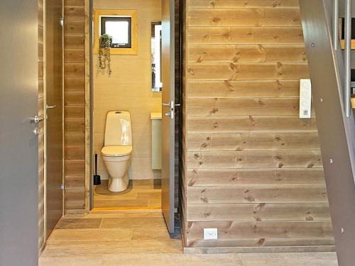 a bathroom with a toilet and a wooden door at Holiday home Sollia in Brenn