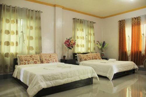 a bedroom with two beds and flowers in it at Casa Michabella Leisure and Events Place in Supa
