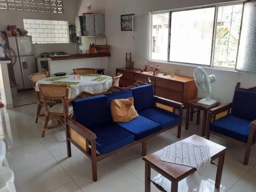 sala de estar con sillas azules y mesa y cocina en Hospedaje casa completa Honda Tolima, en Honda