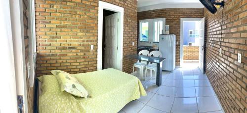 a bedroom with a bed and a brick wall at Chalés Santo Antônio in Flecheiras