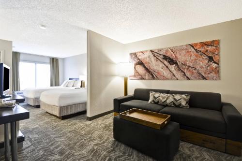 une chambre d'hôtel avec un canapé et un lit dans l'établissement SpringHill Suites by Marriott San Antonio Medical Center/Northwest, à San Antonio