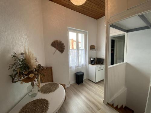 a white room with a table and a mirror at Appartement cosy à Fouras: 1 chambre, proche commerces et plages, Wifi, TV, cuisine équipée - FR-1-709-70 in Fouras