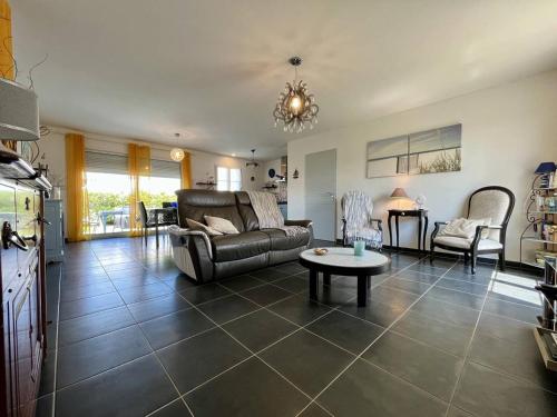 un salon avec un canapé et une table dans l'établissement Maison avec Jardin à Proximité de la Plage - 4 Couchages - Calme et Confort - FR-1-246A-267, à Saint-Georges-dʼOléron